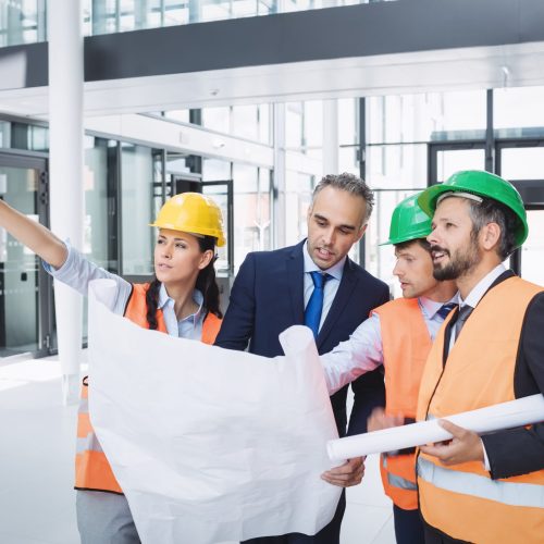 Businessman discussing on blueprint with architects in office building